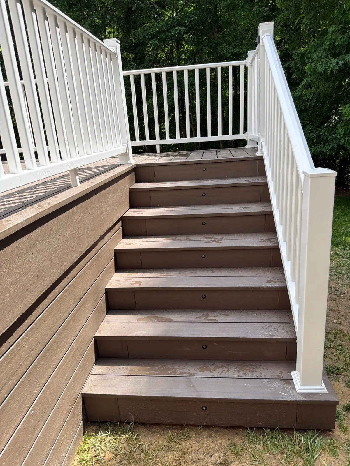 Composite stair treads with white vinyl railing detail