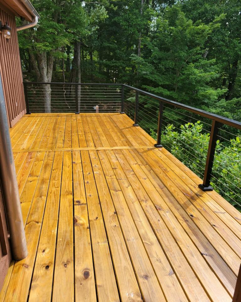 Freshly stained wood deck with cable railing in forest