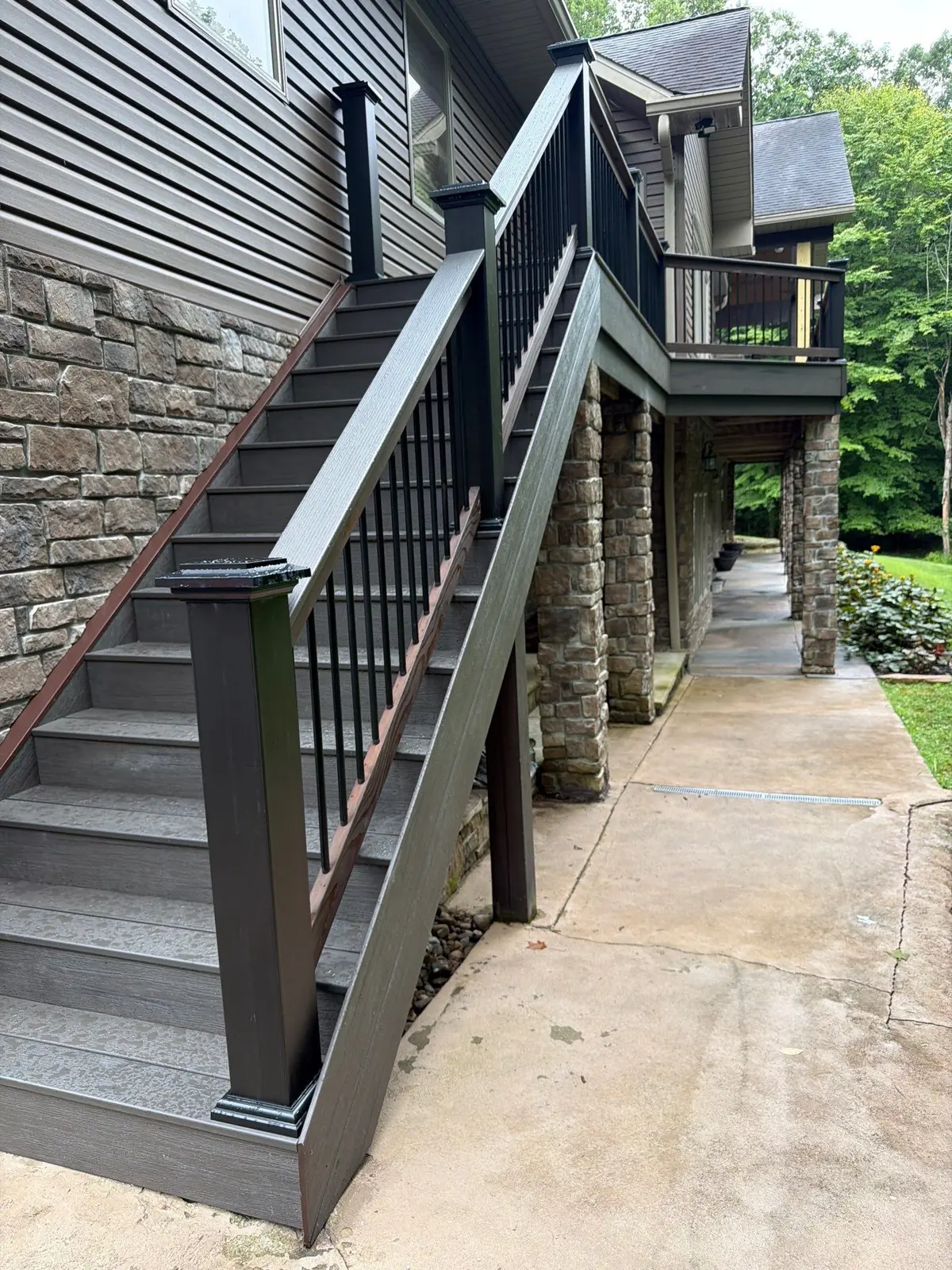 Stone-column walkway with composite decking and metal railing